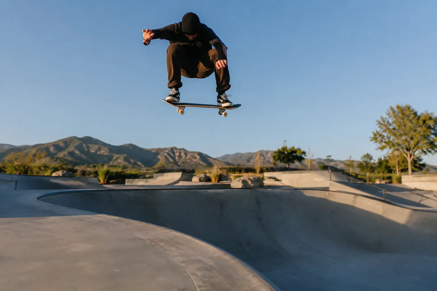 A skateboarder and full board suspended above concrete